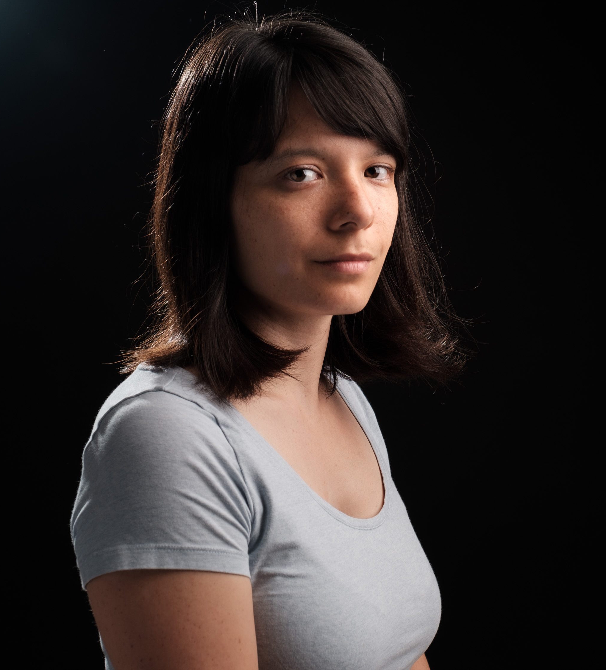 Headshot Aimée de Jongh artist. She has shoulder length brown hair and brown eyes. She is wearing a grey T Shirt.